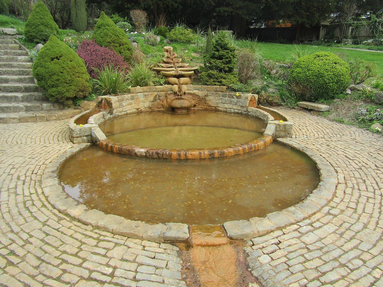 Tapa ornamentada del pozo de Chalice Well entre los jardines