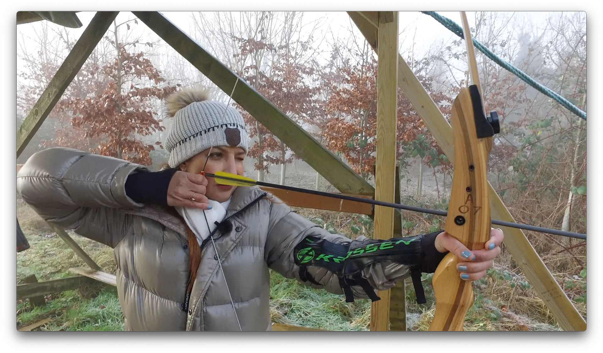 Cathy drawing a bow at an outdoor archery experience