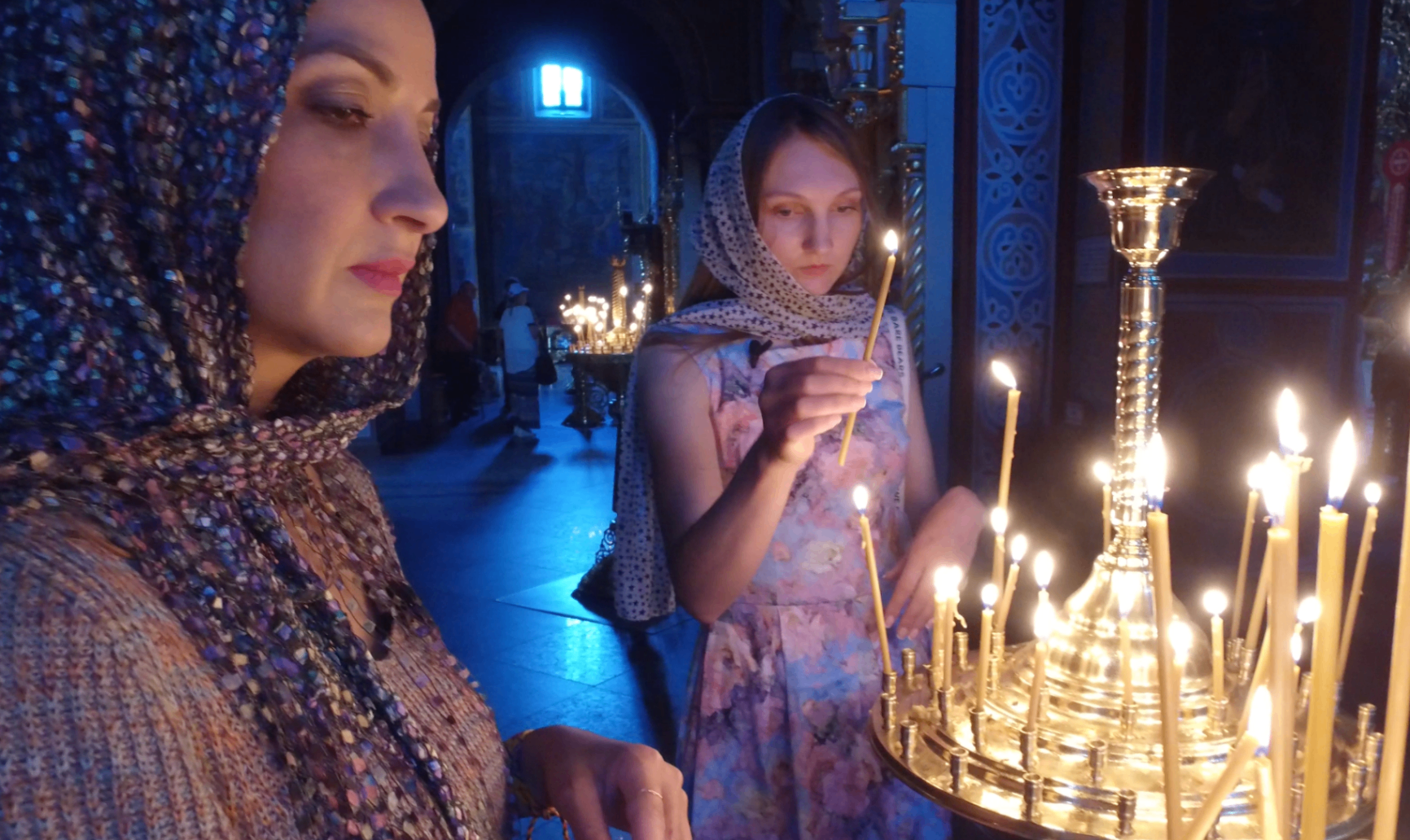 Cathy lighting candles inside a church