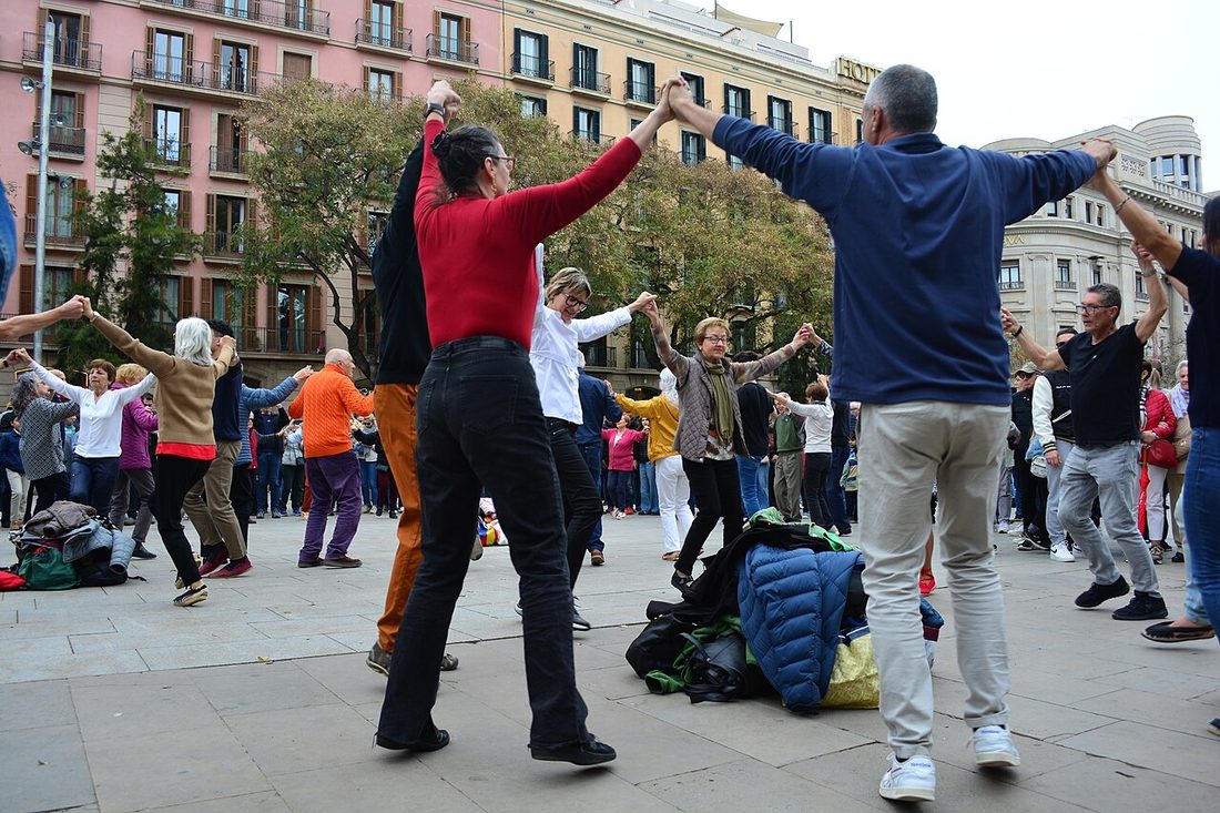 Plaza del Pla de la Seu frente a la Catedral de Barcelona con gente bailando sardanas